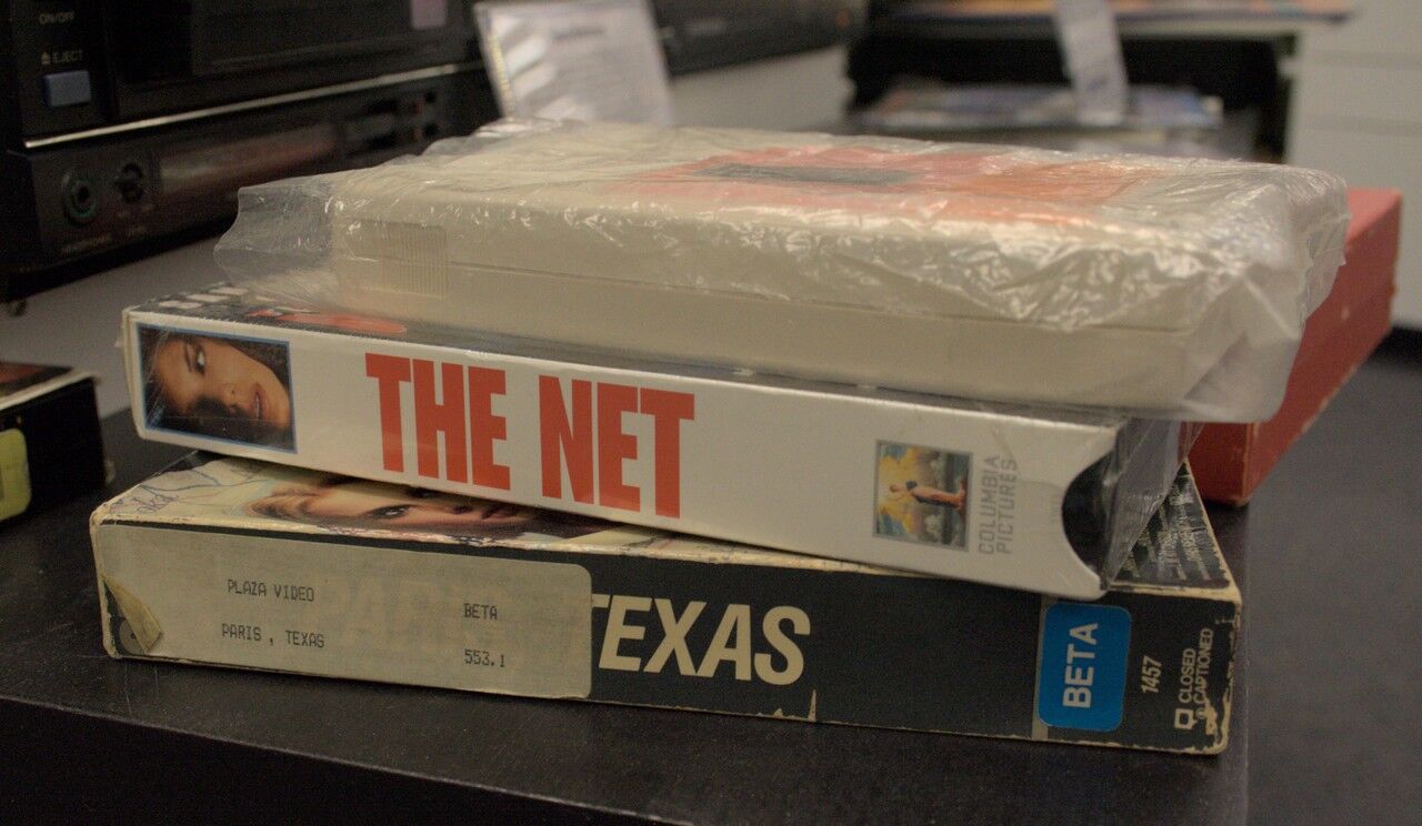 A VHS copy of The Net, sitting on top of a VHS copy of Paris, Texas.
