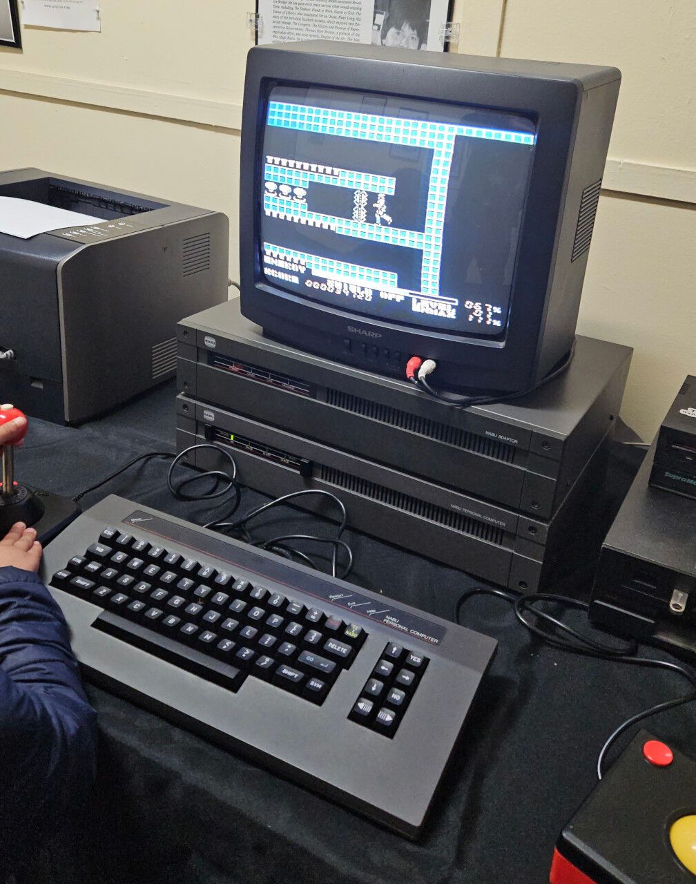 A Nabu computer running a game. Someone is standing on the left playing the game.
